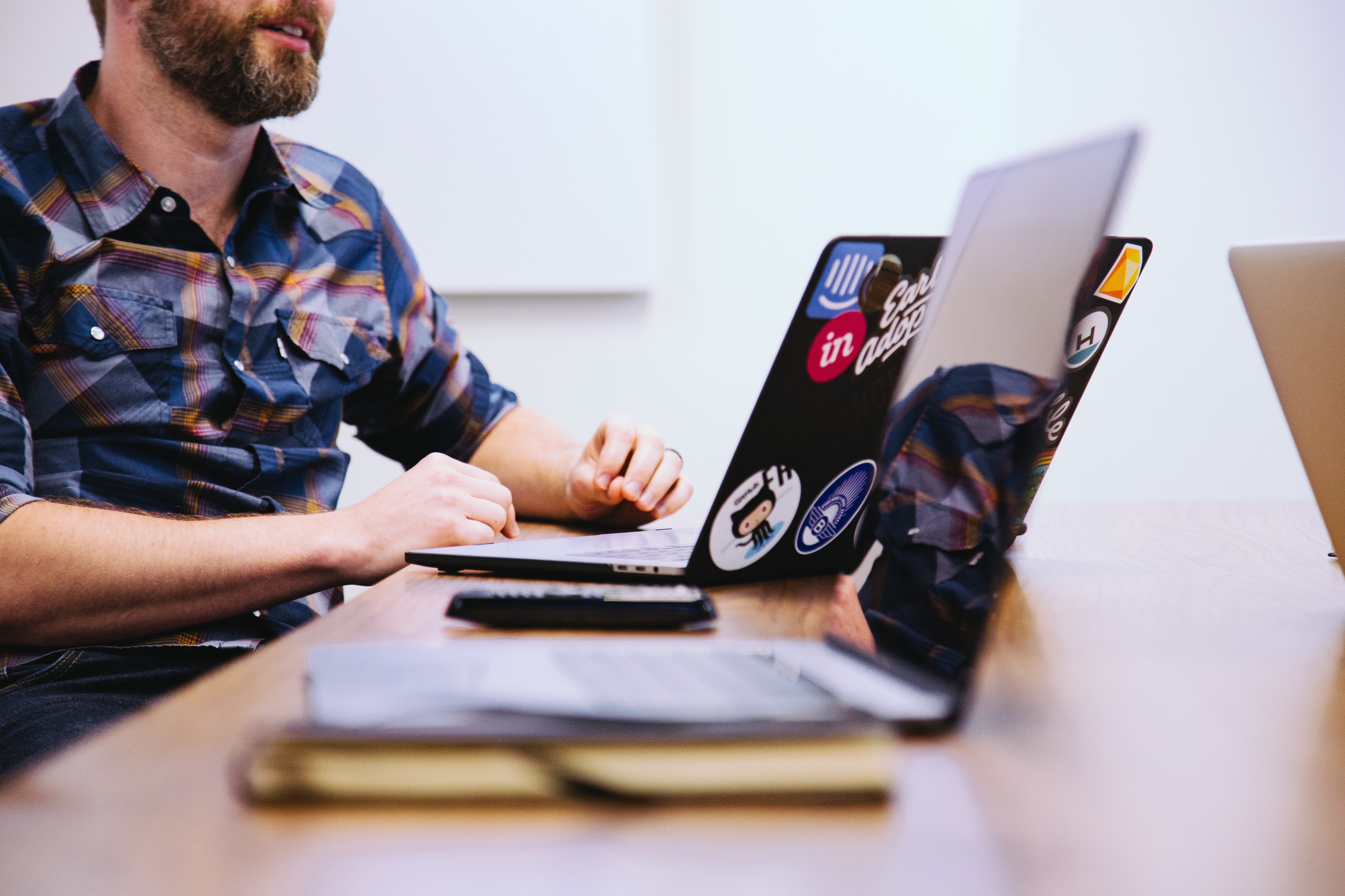 a man in front of a table working with a laptop while looking for animation jobs in the internet