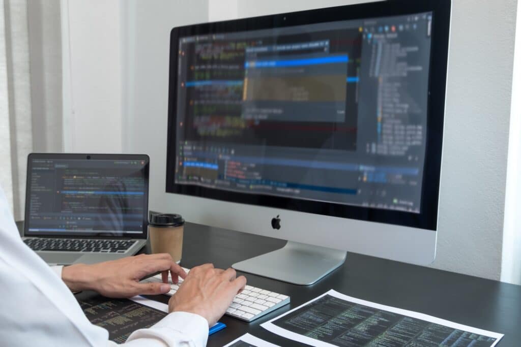 computer programmer working on his laptop and PC