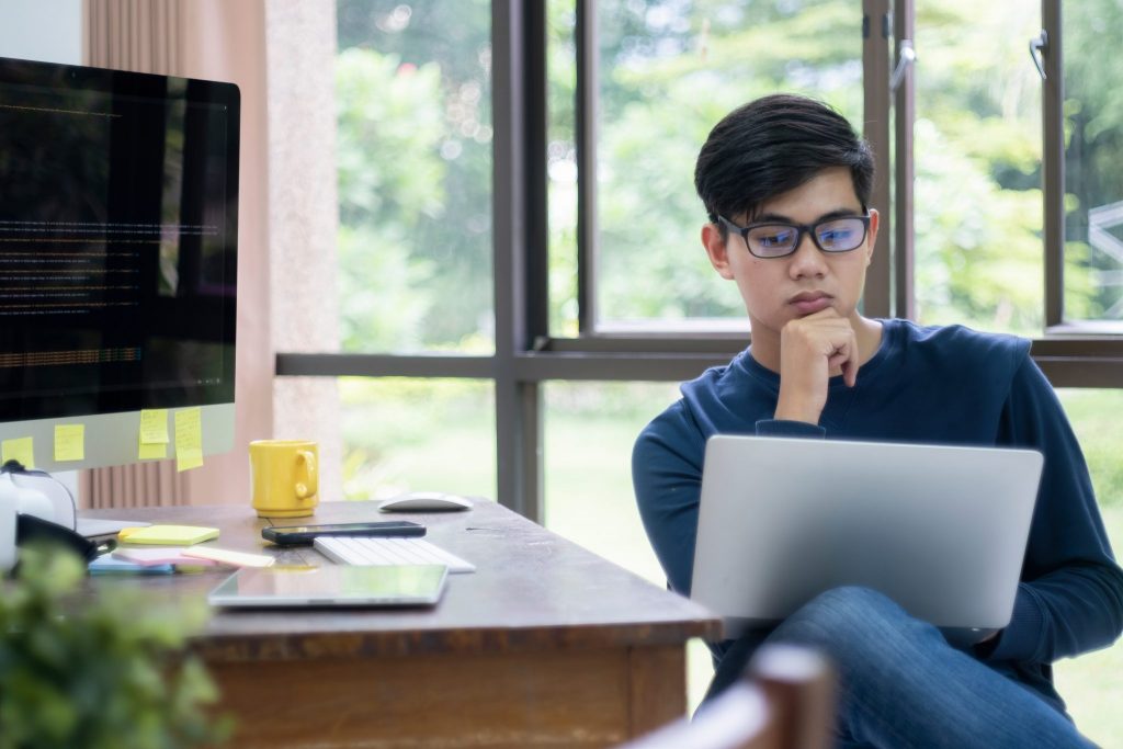 A male student studying to overcome common misconceptions about computer science