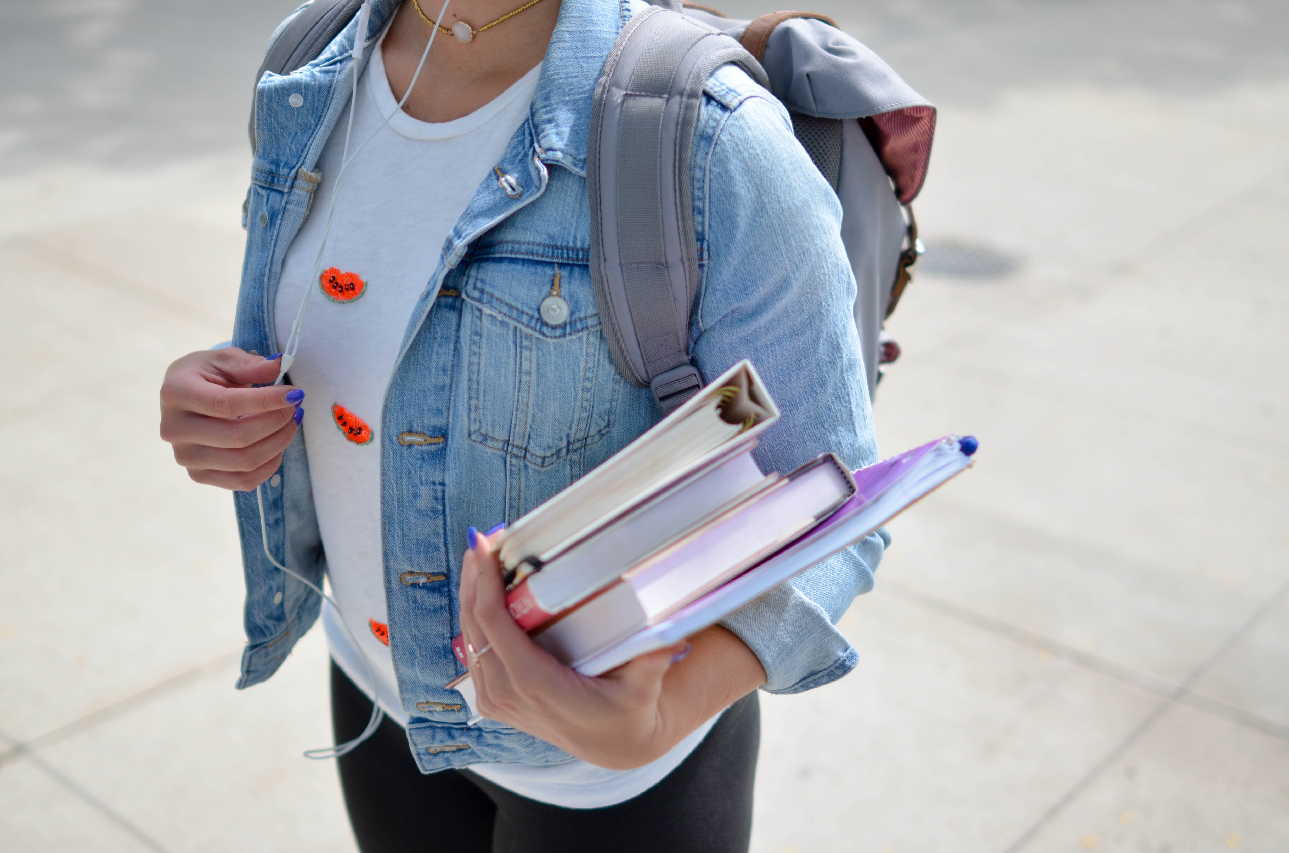 One of the Senior High School graduates holding books and wearing a backpack