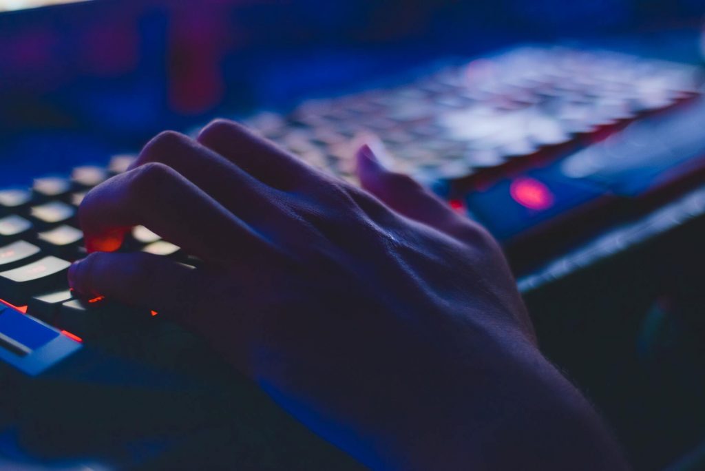 A hand typing “computer science vs computer engineering” on a search engine using a keyboard