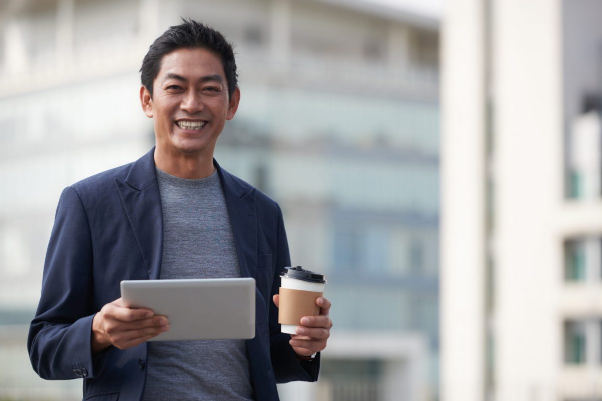 A man holding coffee and tablet work in corporate entrepreneurship