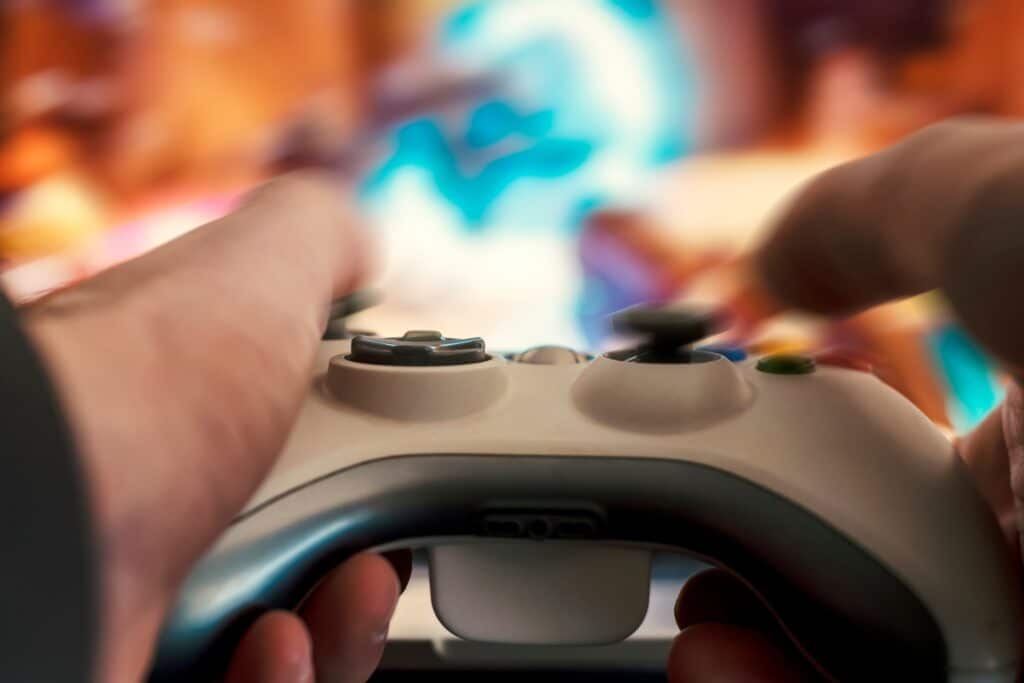 person using a video game controller in front of a screen