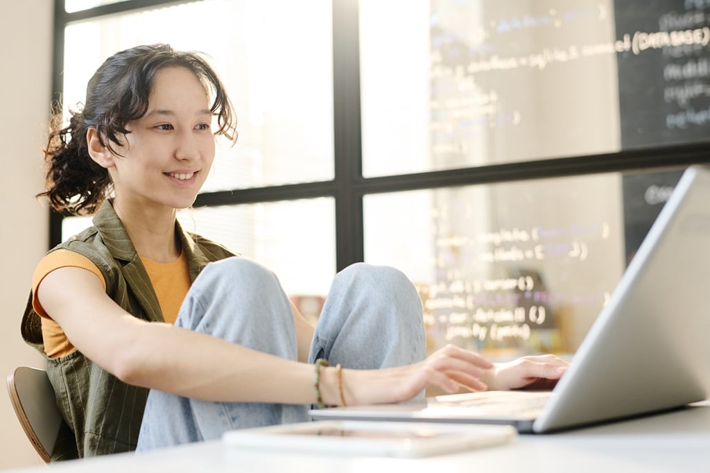 student entering various codes using a laptop