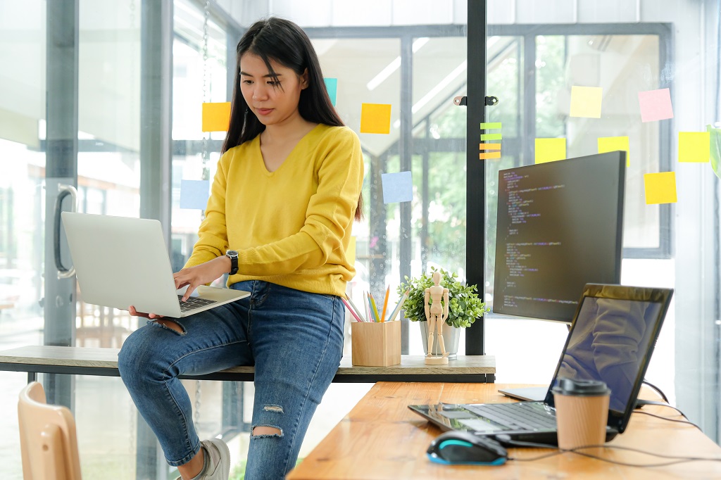 Asian female programmer using laptop and know the importance of computer programming