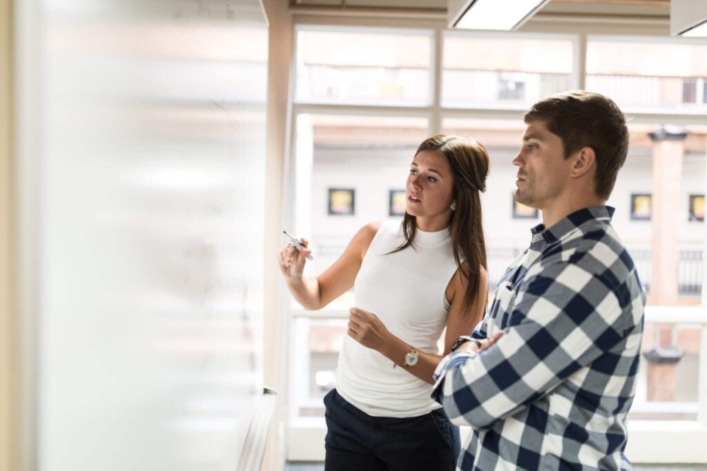 young entrepreneurs using whiteboard to discuss business strategies